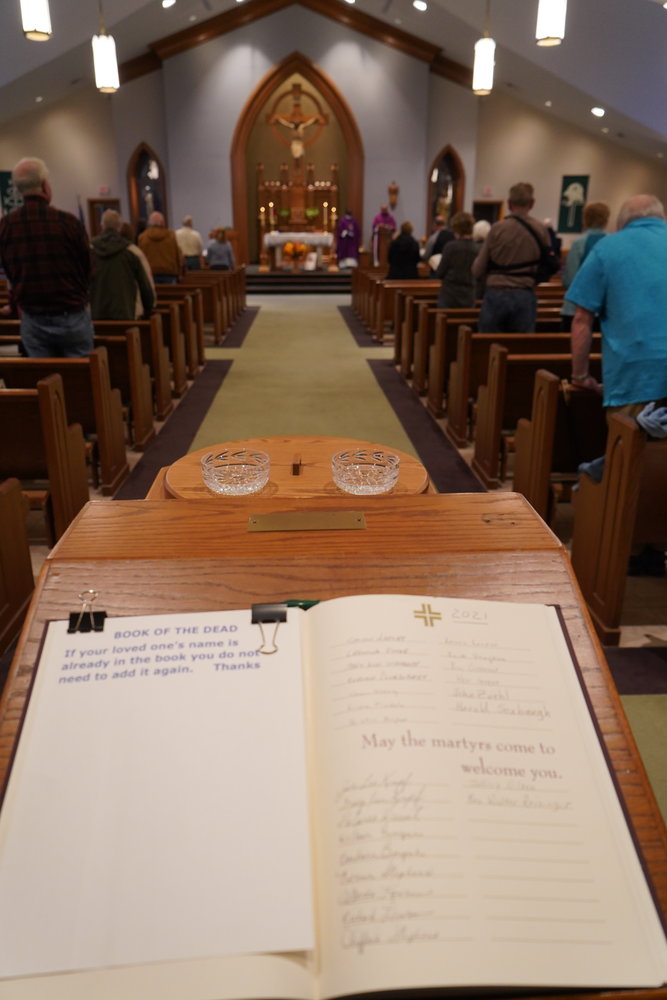 The Book of the Dead, containing the names of parishioners and of friends and loved ones who have died, greets people as they enter St. Andrew Church the evening of Nov. 2, All Souls Day.